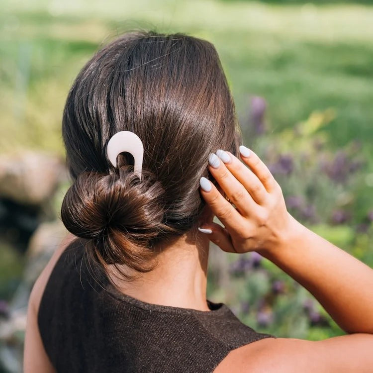 Doodlations Coffee Bar & Boutique Teleties French hair pin in coconut white securing a chic bun in dark hair