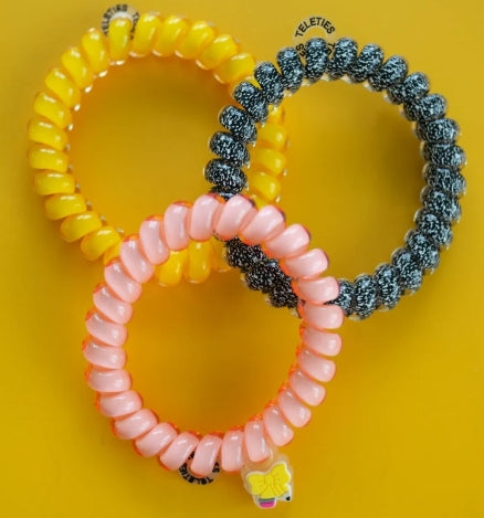 Doodlations Coffee Bar & Boutique Teleties Study Buddy hair ties in yellow, pink, and black glitter on yellow background