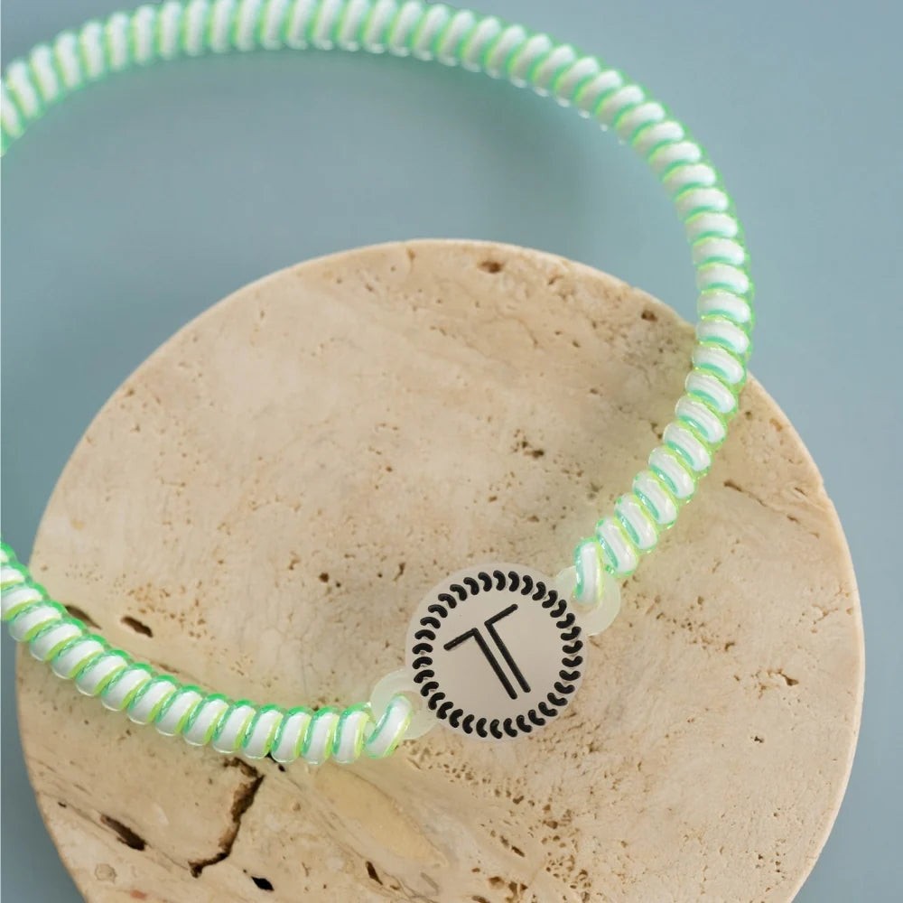 Doodlations Coffee Bar & Boutique Teleties headband in a spiral green and white design with a branded rubber charm.