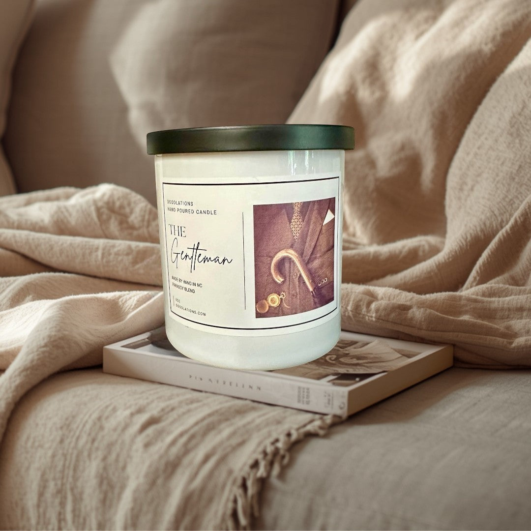 Doodlations Coffee Bar & Boutique The Gentleman luxury soy blend candle with masculine cologne scent. Features a suit, tie, cane, and monocle.