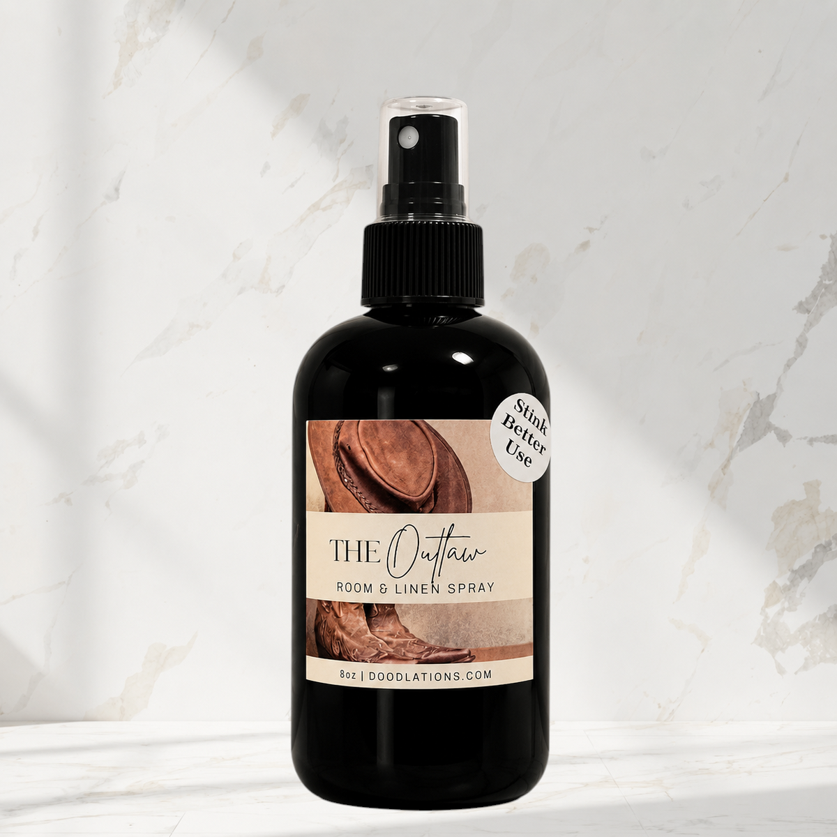 Doodlations Coffee Bar & Boutique The Outlaw room and linen spray in a black bottle with a western-themed label.