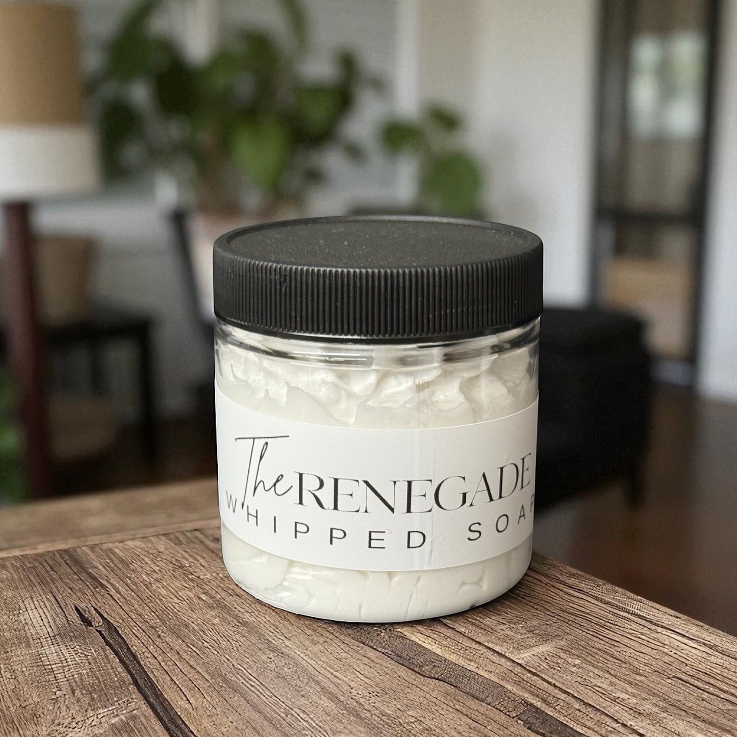 Doodlations Coffee Bar & Boutique The Renegade whipped soap in a clear jar with black lid on a wooden surface.