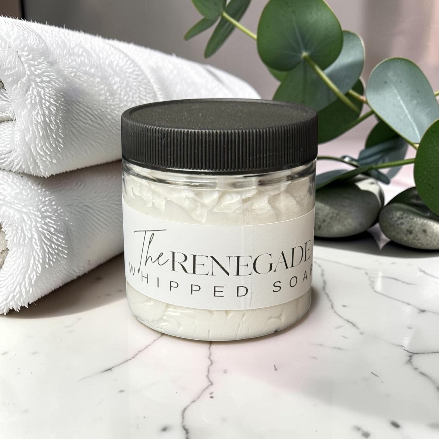 Doodlations Coffee Bar & Boutique The Renegade whipped soap in a clear jar with black lid on a wooden surface.