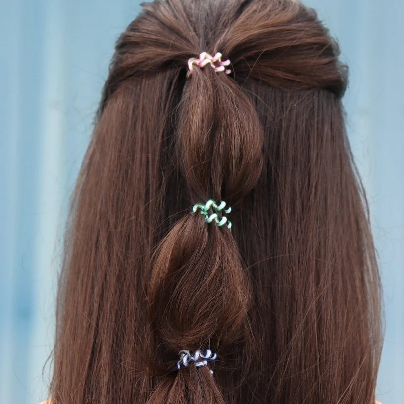 Doodlations Coffee Bar & Boutique Shades of Summer tiny hair coils in pink, green, and blue securing a braided hairstyle