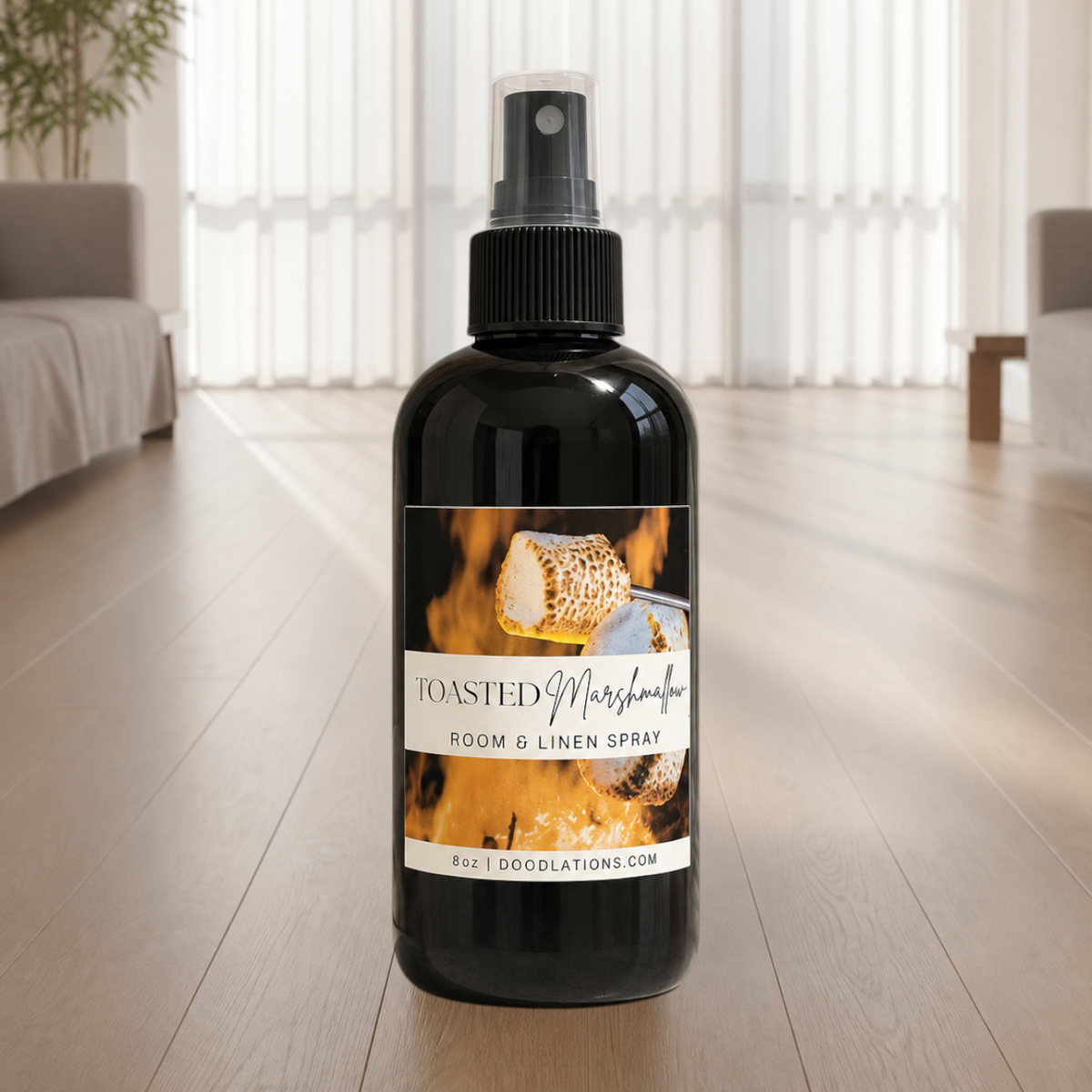 Doodlations Coffee Bar & Boutique Toasted Marshmallow room and linen spray in a black bottle on a wooden floor.