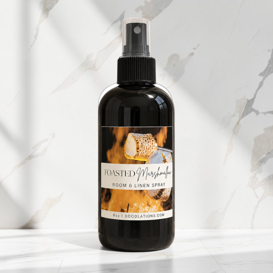 Doodlations Coffee Bar & Boutique Toasted Marshmallow room and linen spray in a black bottle on a marble surface.