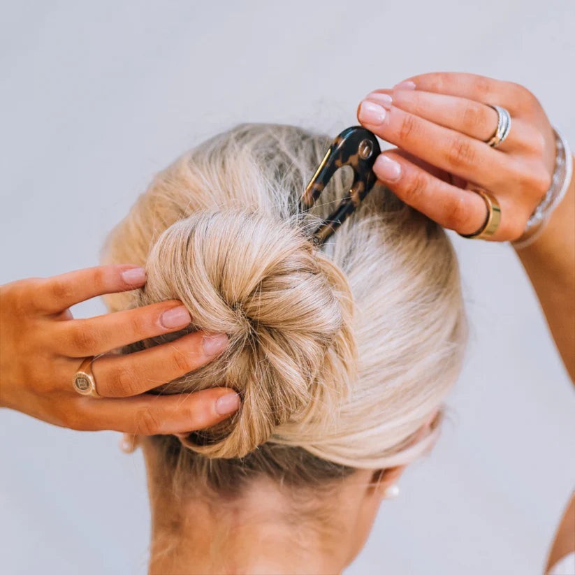 Doodlations Coffee Bar & Boutique Teleties French hair pin in a tortoiseshell pattern securing a blonde hair bun