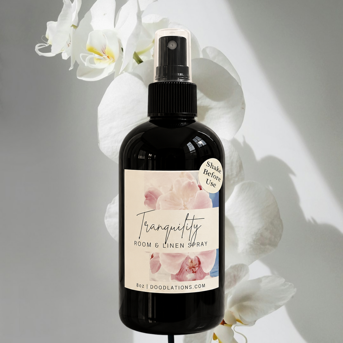 Doodlations Coffee Bar & Boutique Tranquility room and linen spray in a black bottle with a floral label and orchids.