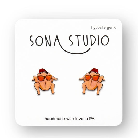 Doodlations Coffee Bar & Boutique Friends turkey earrings with sunglasses and red hats on a display card.