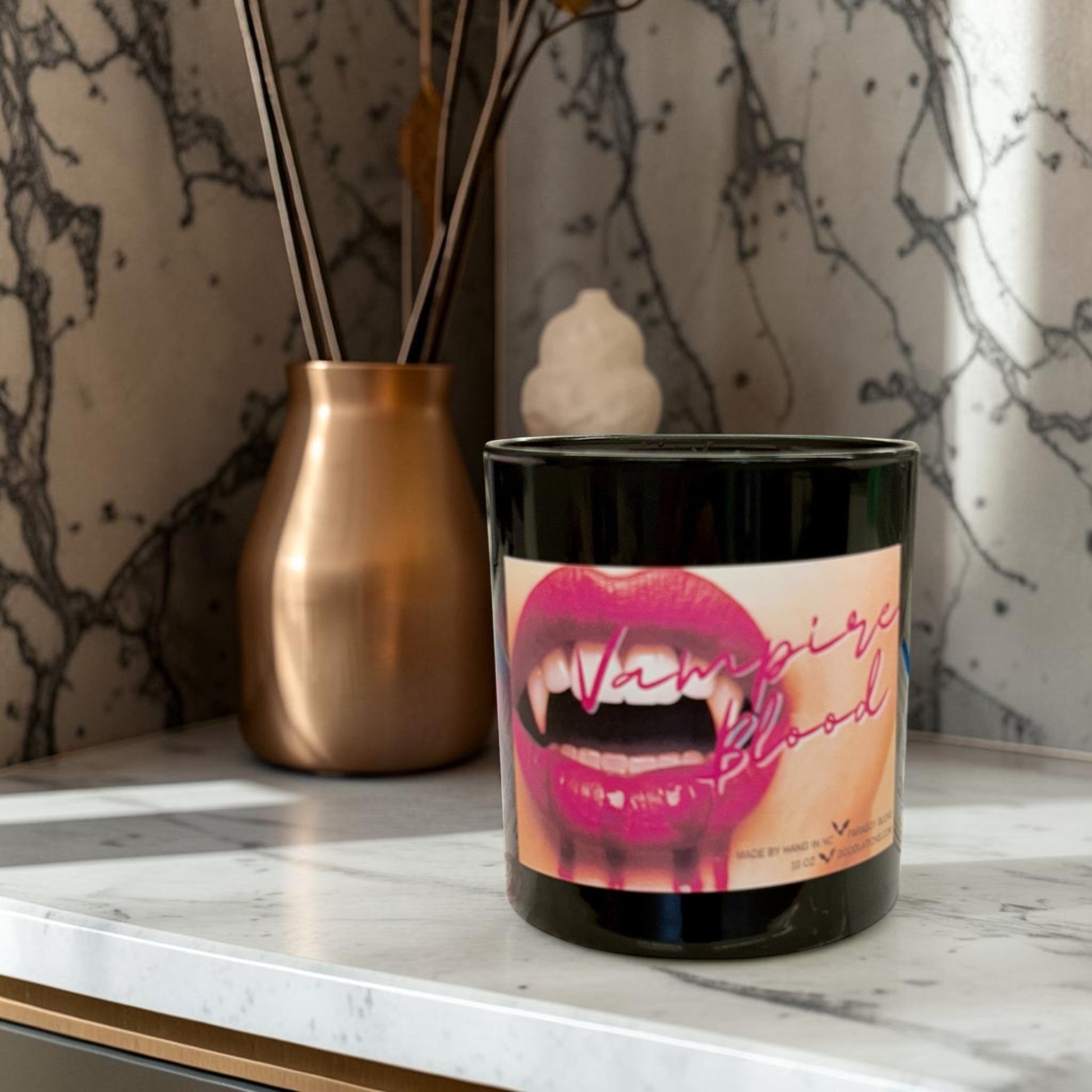 Doodlations Coffee Bar & Boutique Vampire Blood luxury candle with decorative wax fangs and bats. Dark berry, jasmine, amber scent.