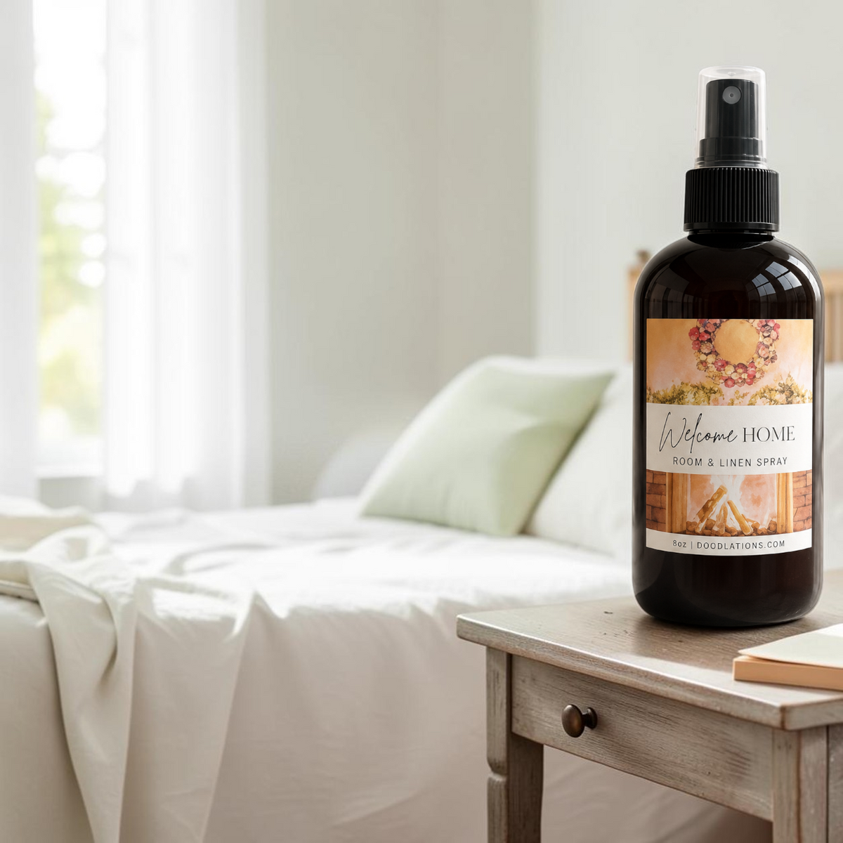 Doodlations Coffee Bar & Boutique Welcome Home luxury room and linen spray in an amber bottle on a wooden nightstand.