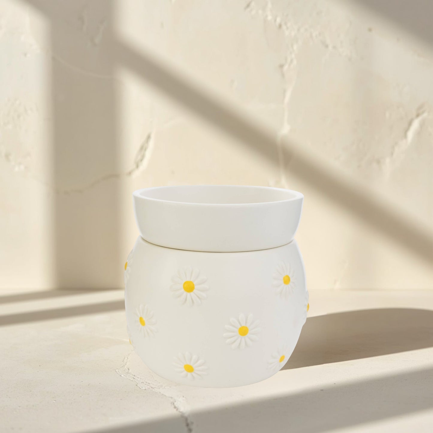 Doodlations Coffee Bar & Boutique white ceramic wax warmer with raised daisy design and yellow centers.