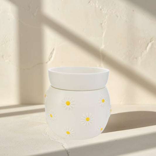 Doodlations Coffee Bar & Boutique white ceramic wax warmer with raised daisy design and yellow centers.