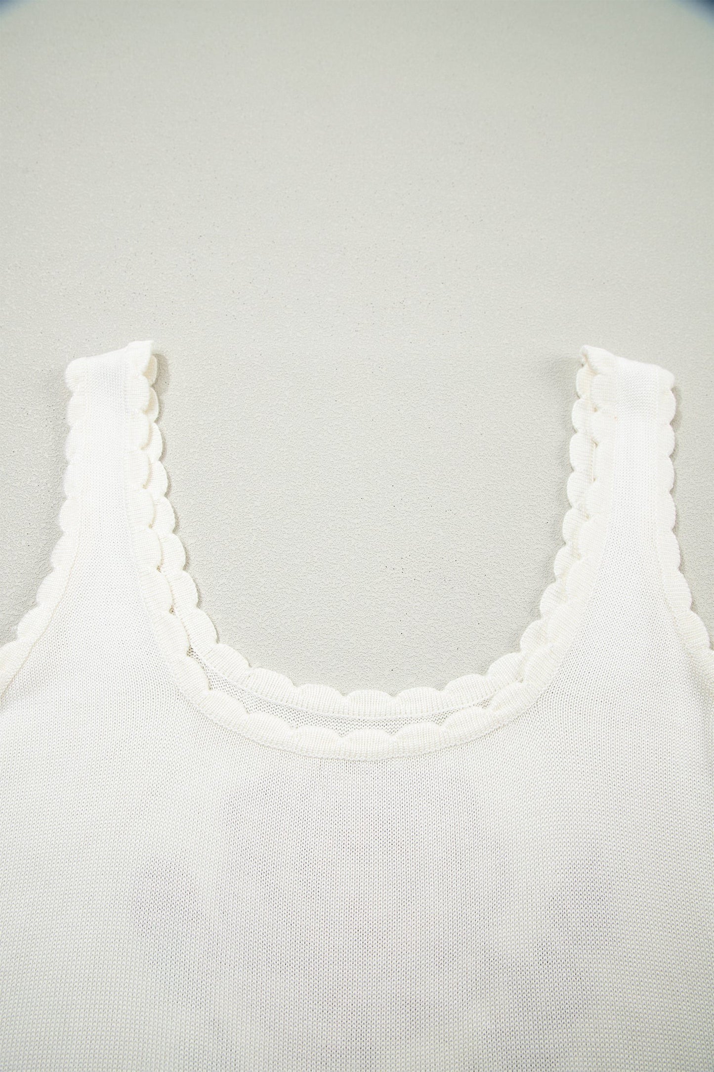 Doodlations Coffee Bar & Boutique white knit tank top featuring a delicate scalloped neckline and sleeveless design.