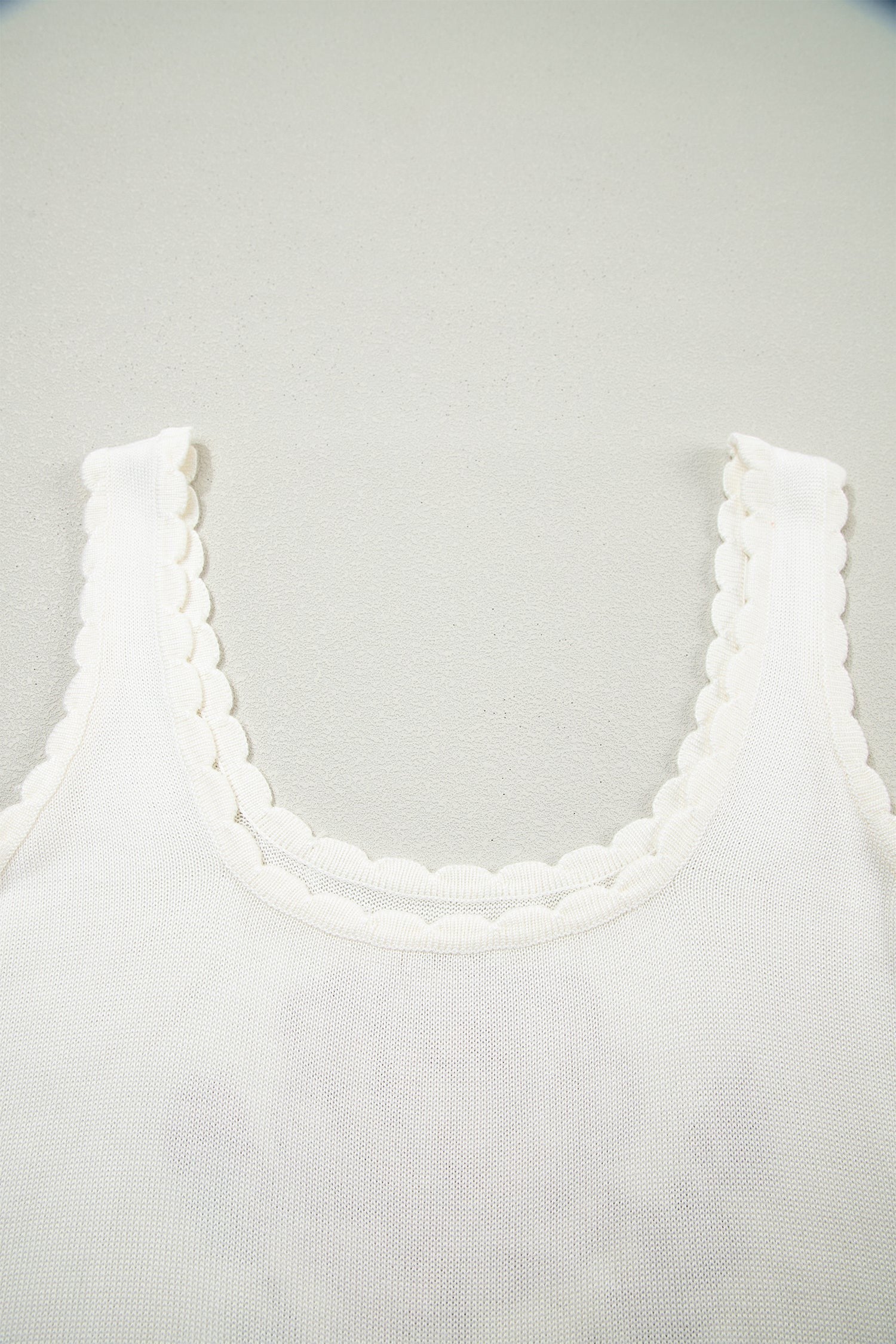 Doodlations Coffee Bar & Boutique white knit tank top featuring a delicate scalloped neckline and sleeveless design.