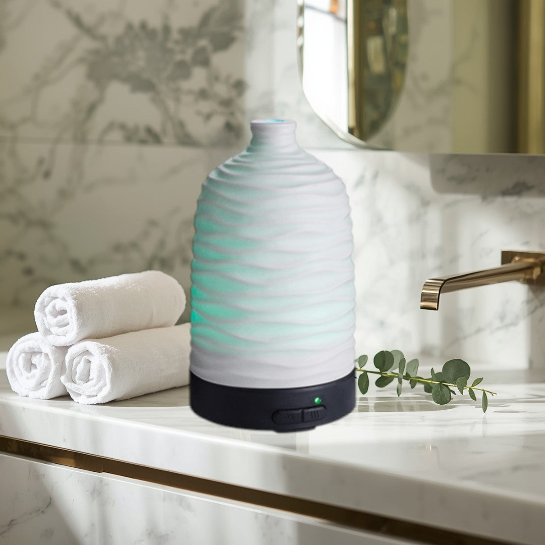 Doodlations Coffee Bar & Boutique white wavy ceramic essential oil diffuser with green LED light