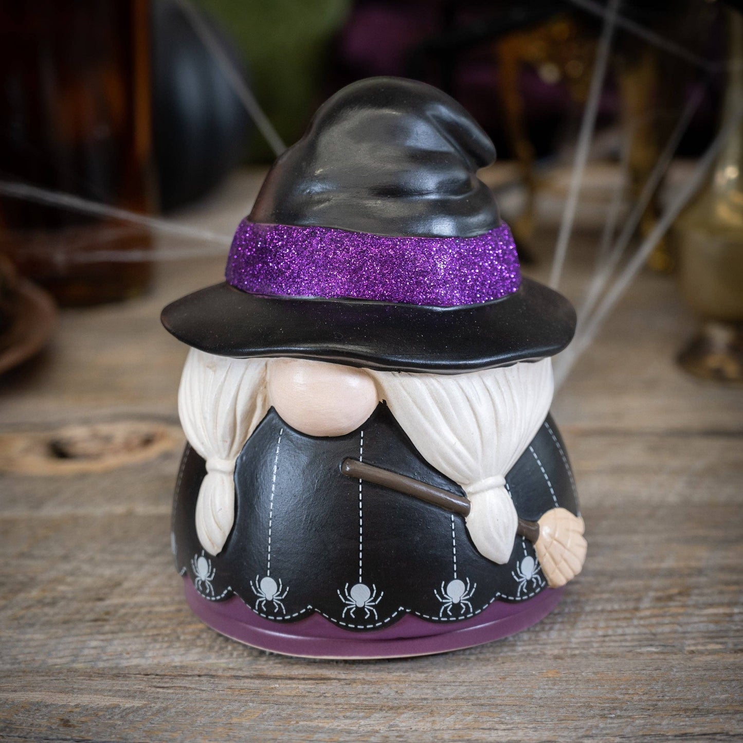 Doodlations Coffee Bar & Boutique ceramic witch gnome wax warmer with a purple glitter hat and spider web base.