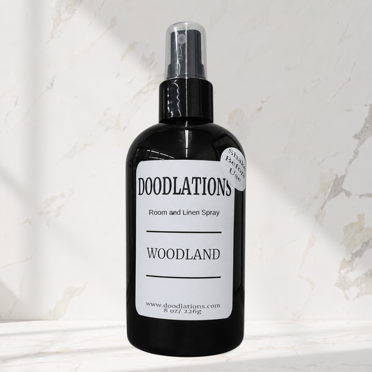 Doodlations Coffee Bar & Boutique Woodland room and linen spray in a black bottle with a white label