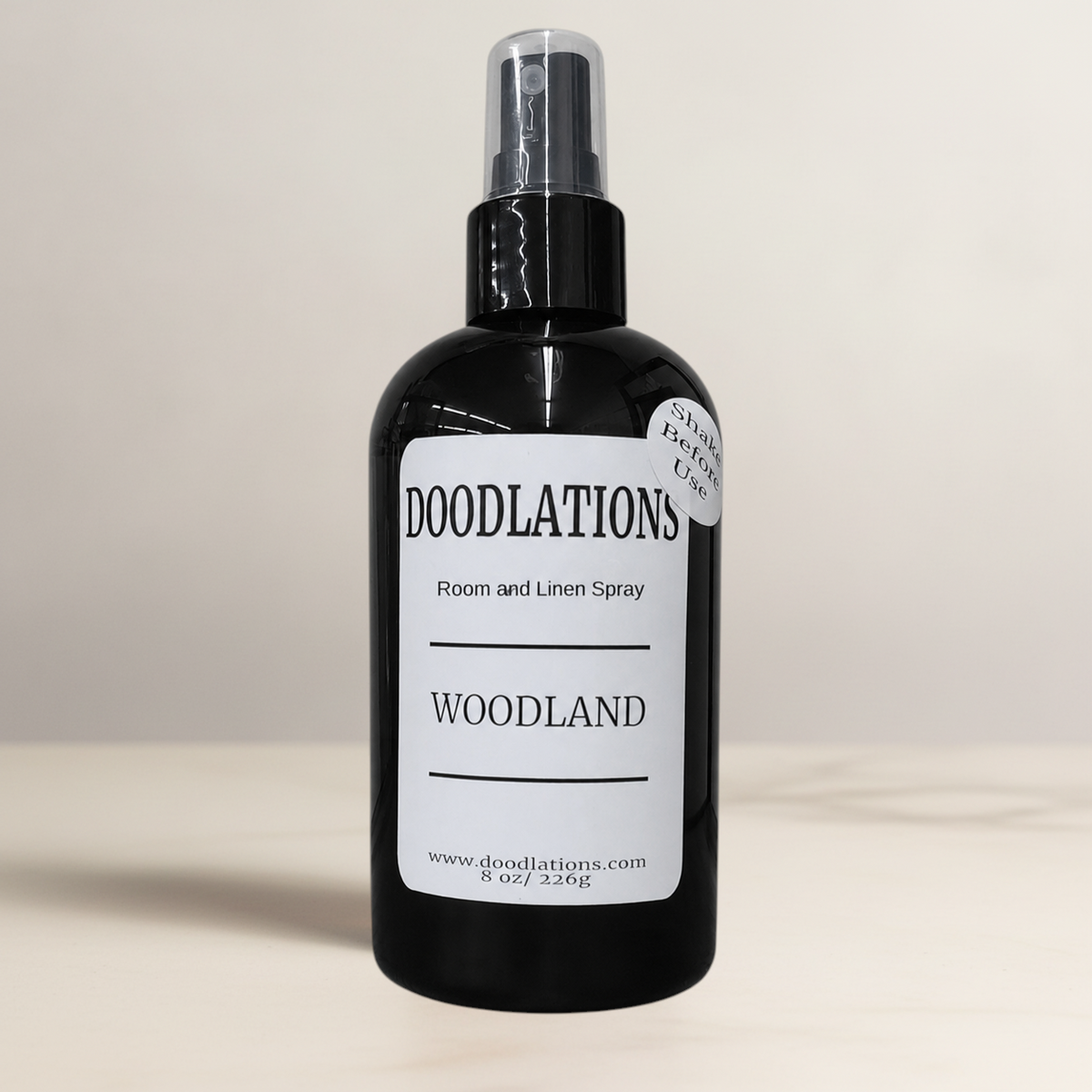 Doodlations Coffee Bar & Boutique Woodland room and linen spray in a black bottle with a white label.