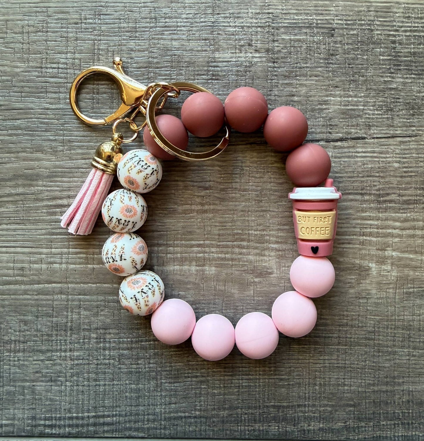 Doodlations Coffee Bar & Boutique beaded keychain bracelet with coffee cup charm, pink tassel, and floral pattern beads.