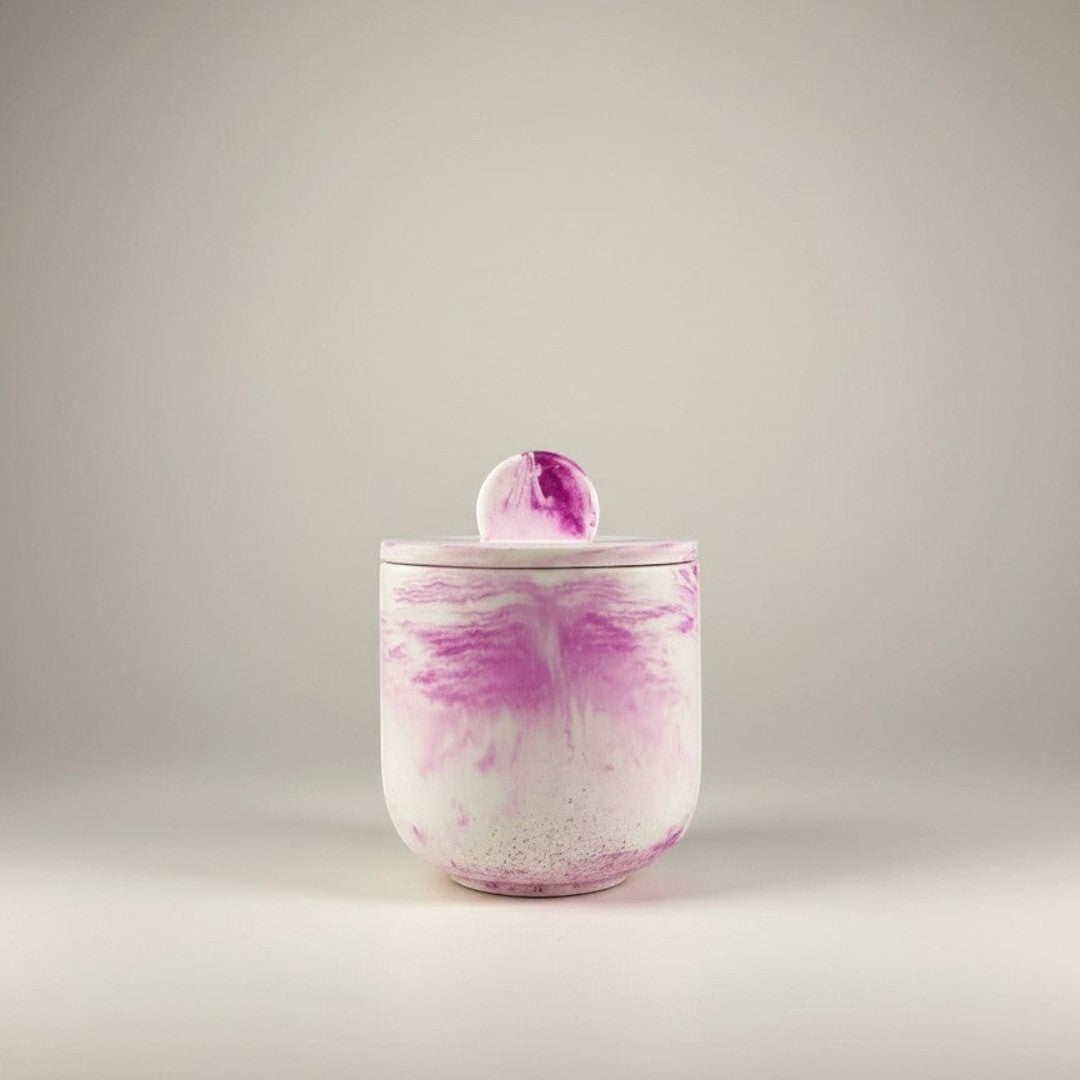 Doodlations Coffee Bar & Boutique luxury hand-poured concrete vessel candle with pink marbling and lid.