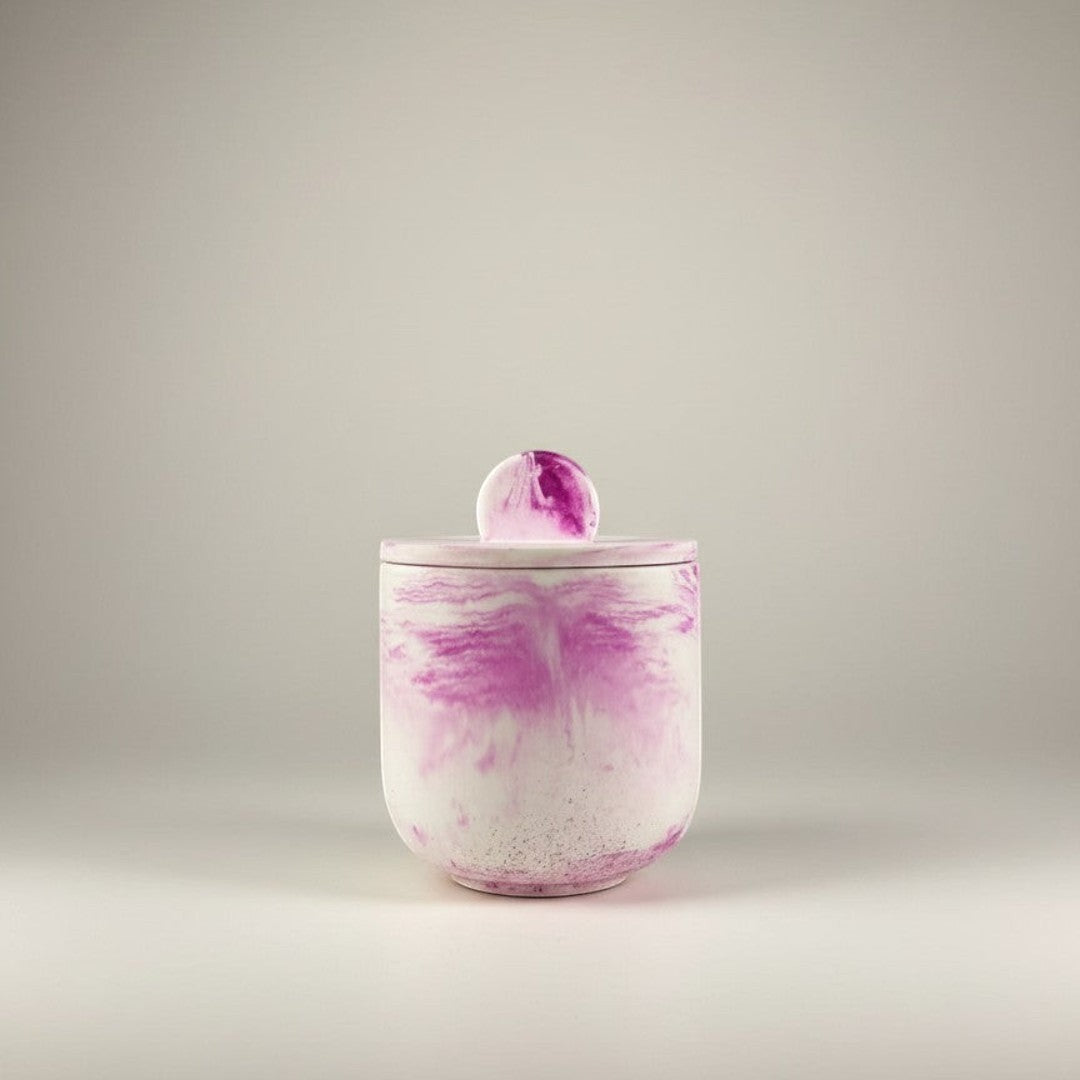 Doodlations Coffee Bar & Boutique luxury hand-poured concrete vessel candle with pink marbling and lid.