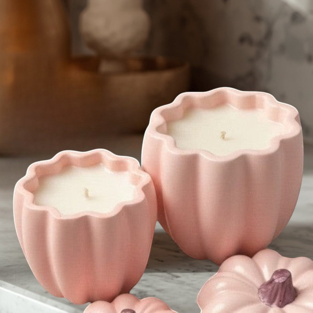 Doodlations pink concrete pumpkin candles in two sizes, with decorative pumpkin lids.