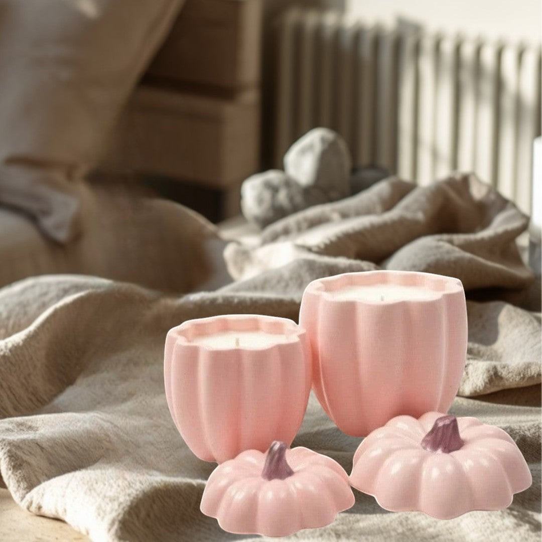 Doodlations pink concrete pumpkin candles in two sizes, with decorative lids.