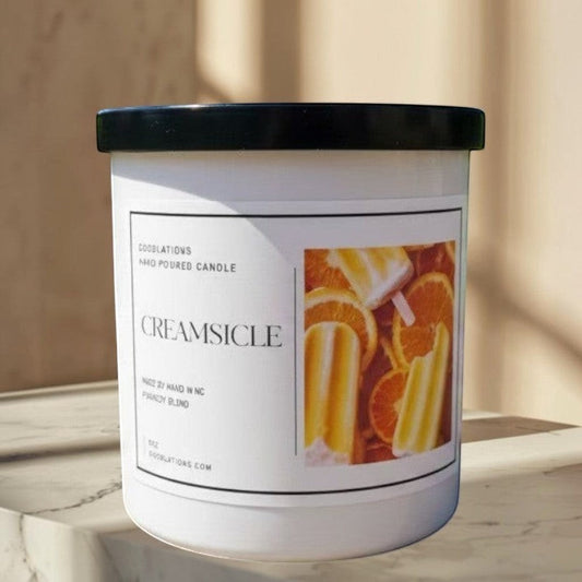 Doodlations hand-poured candle with a creamy orange citrus scent, featuring a label with orange slices and creamsicles.