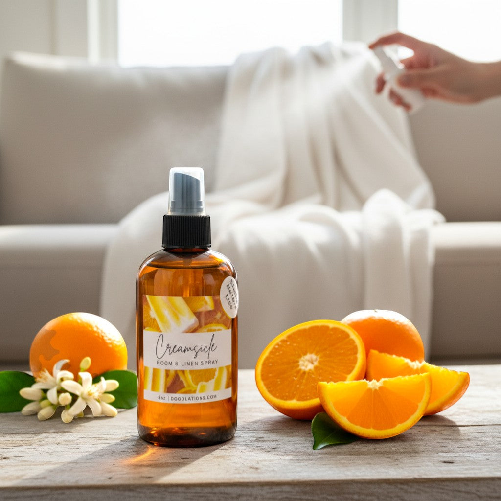 Doodlations Coffee Bar & Boutique Creamsicle Room & Linen Spray with citrus notes, in amber bottle with oranges.