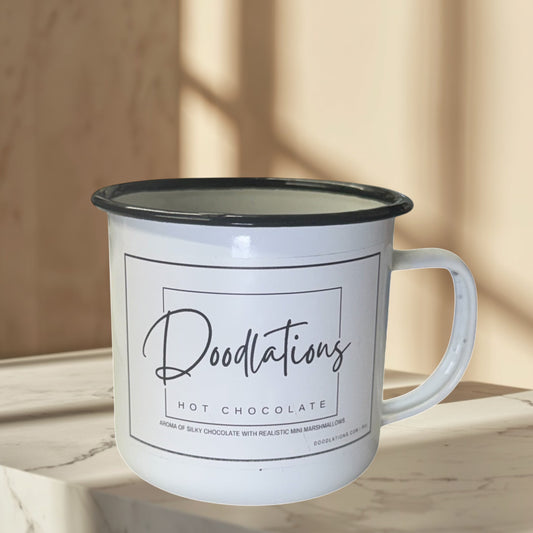 Doodlations white enamel camping mug candle with hot chocolate scent and black rim.
