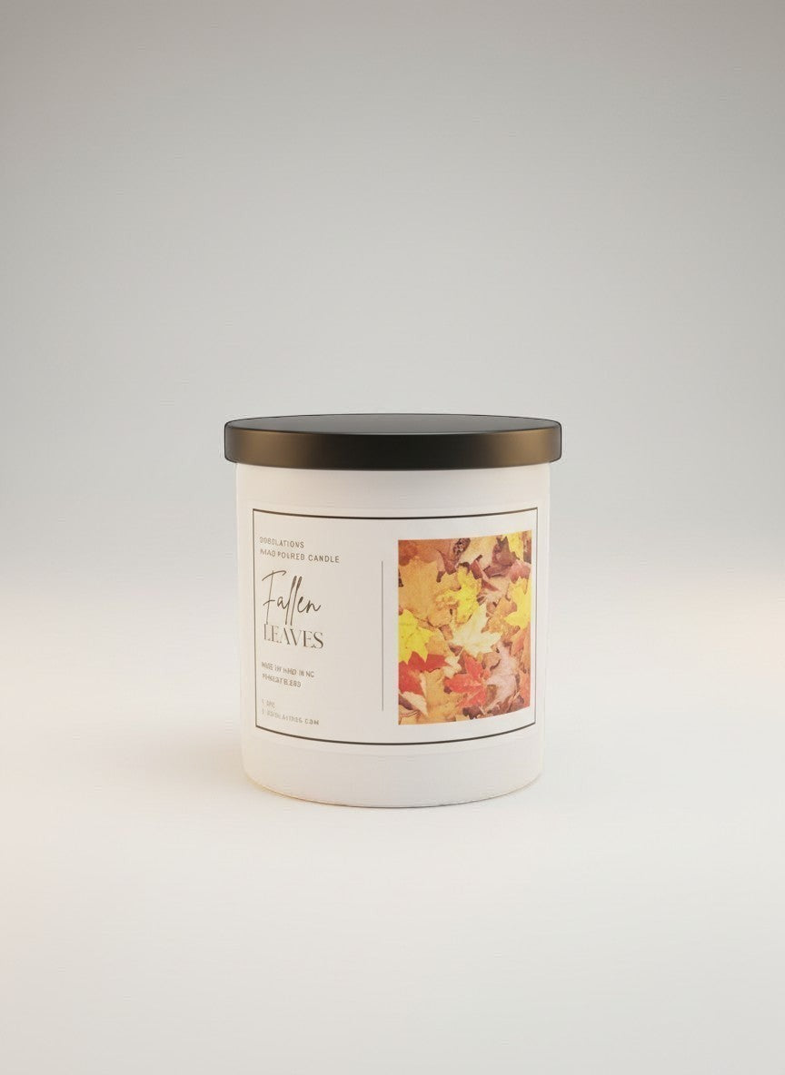 Doodlations Coffee Bar & Boutique Fallen Leaves candle with a black lid, featuring a label with autumn leaves imagery and warm scent notes.