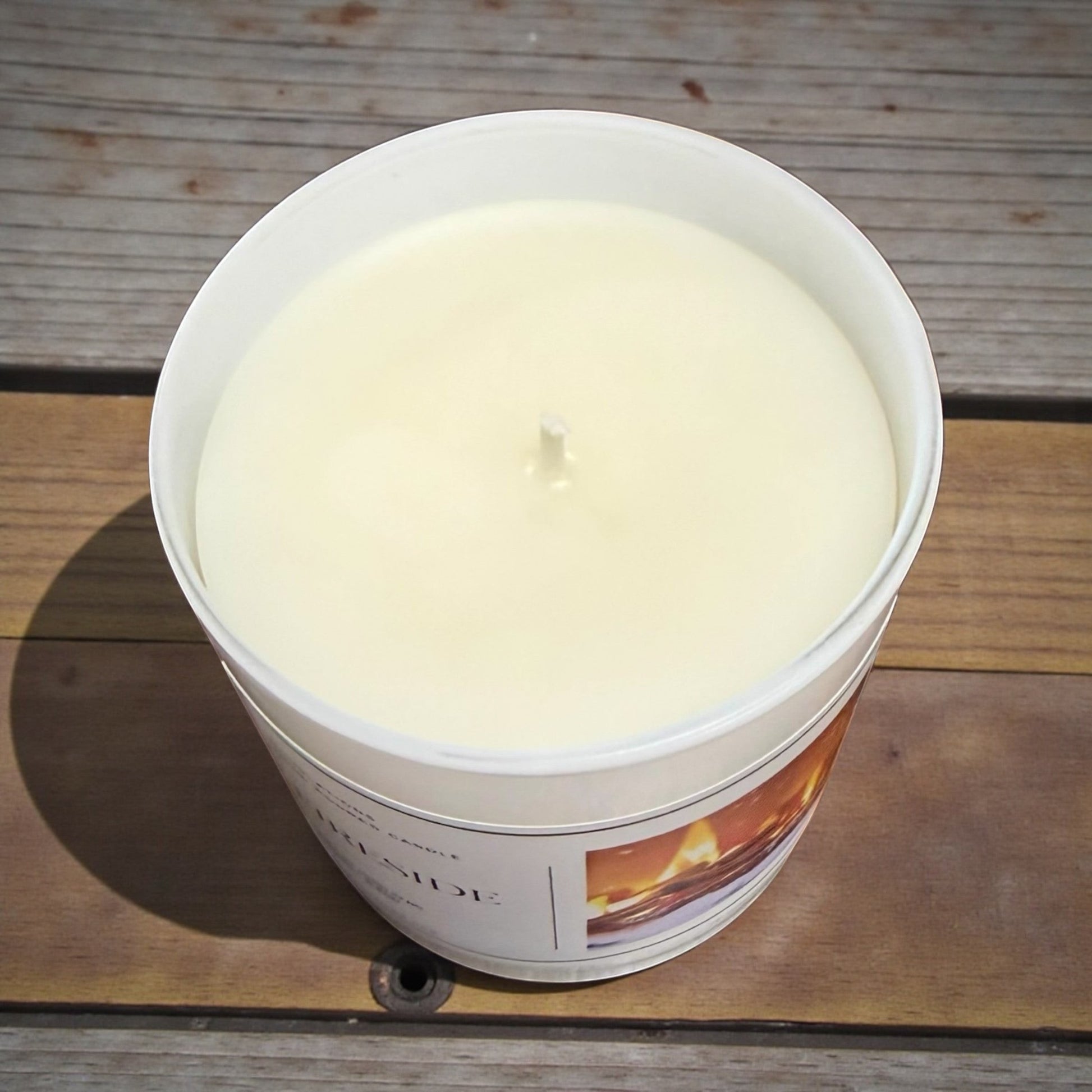 Doodlations Coffee Bar & Boutique Fireside candle with a creamy white wax and a single wick, set on a wooden surface.