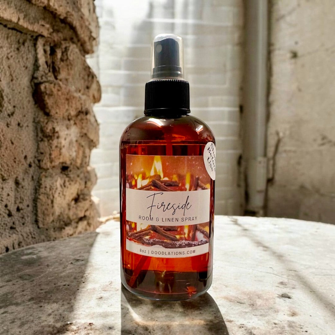 Doodlations Coffee Bar & Boutique Fireside room and linen spray with smoky wood and clove scent. Amber glass bottle.
