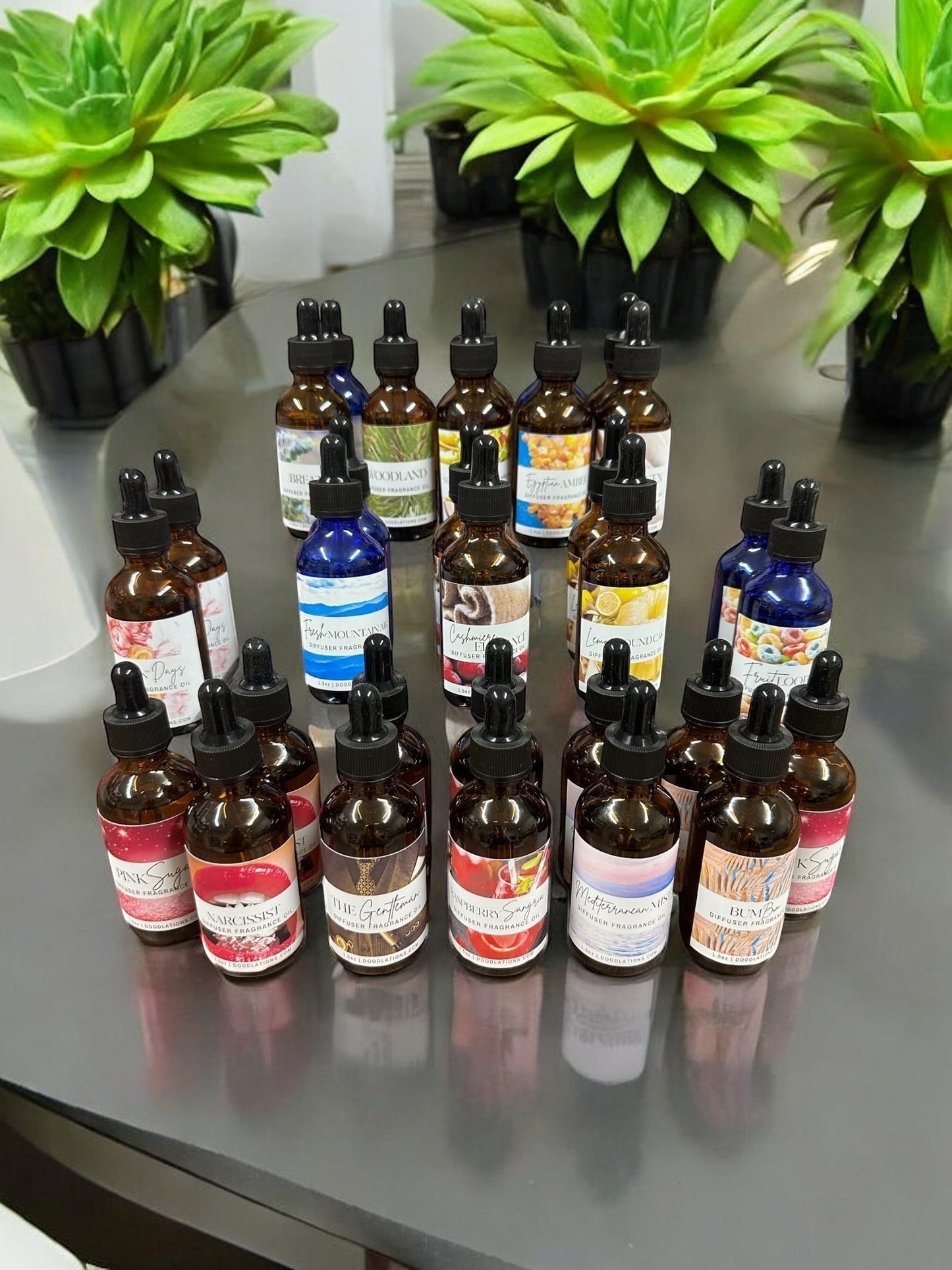 Doodlations Coffee Bar & Boutique Artisan Diffuser Fragrance Oil Collection bottles with dropper tops. Assorted scents like Pink Sage, Narcissist, The Gentleman, and Mediterranean Mix.