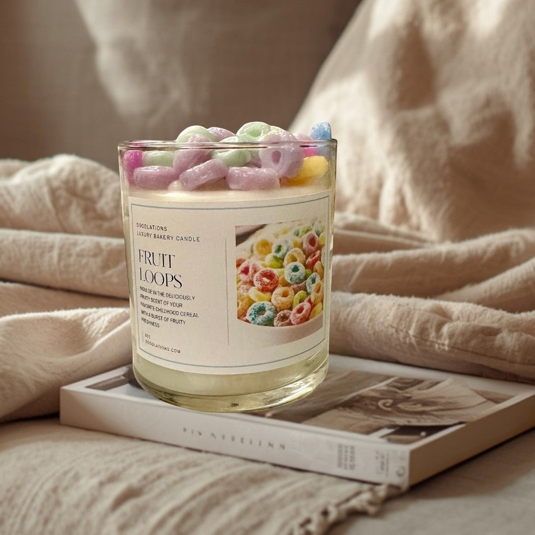 Doodlations Fruit Loops luxury bakery candle in a glass jar, topped with colorful cereal pieces. Fruity scent.