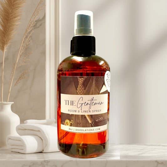 Doodlations The Gentleman room and linen spray in amber bottle with suit label. Notes of mahogany, blood orange, bourbon vanilla, amber, sandalwood.