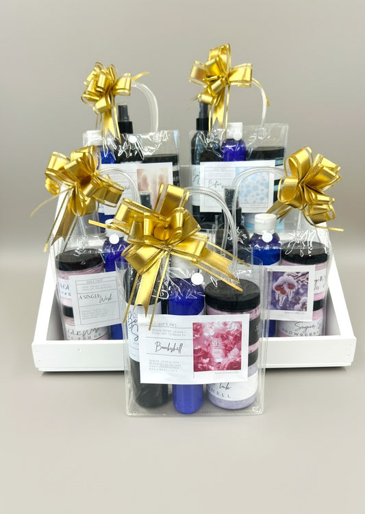 Doodlations Coffee Bar & Boutique gift set with bath bombs, lotions, and sprays, tied with gold bows.