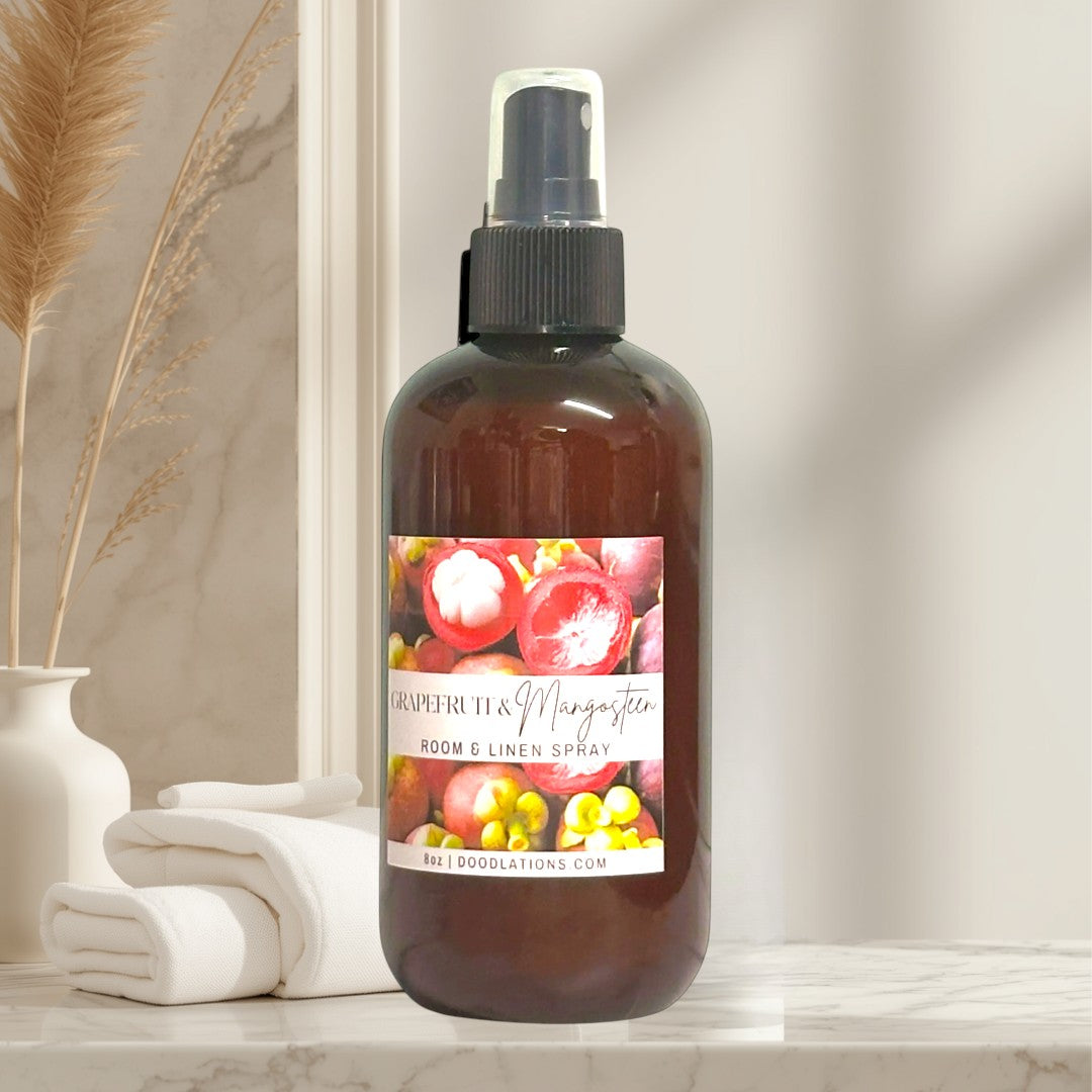 Doodlations Coffee Bar & Boutique Grapefruit & Mangosteen room and linen spray in amber bottle with fruity label.