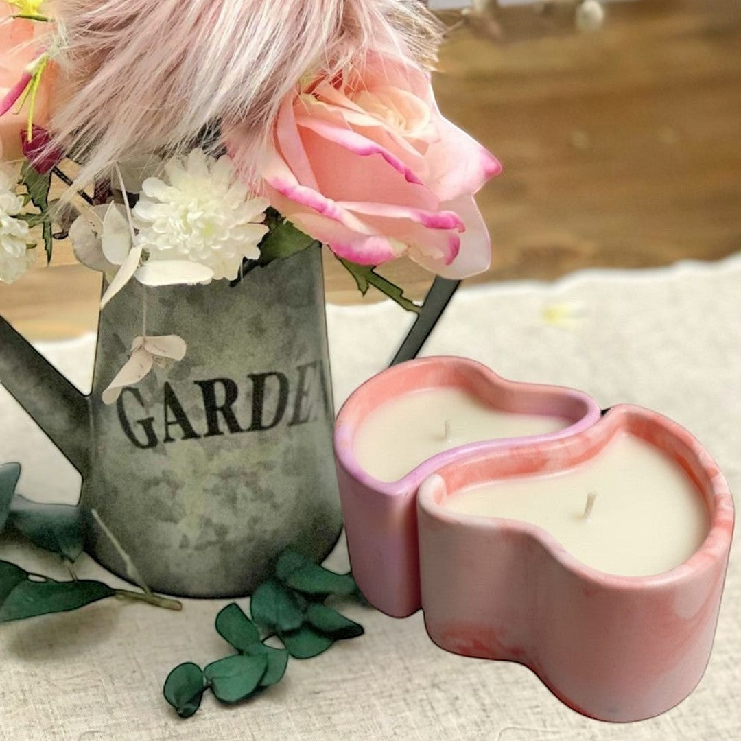 Doodlations Coffee Bar & Boutique heart-shaped concrete candle with pink and white marbling, filled with creamy soy wax.