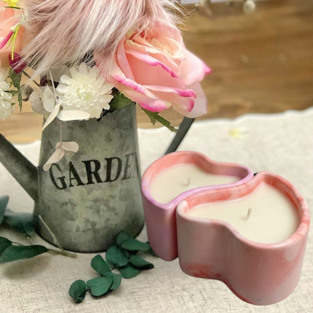Doodlations Coffee Bar & Boutique heart-shaped concrete candle with pink and white marbling, filled with creamy soy wax.