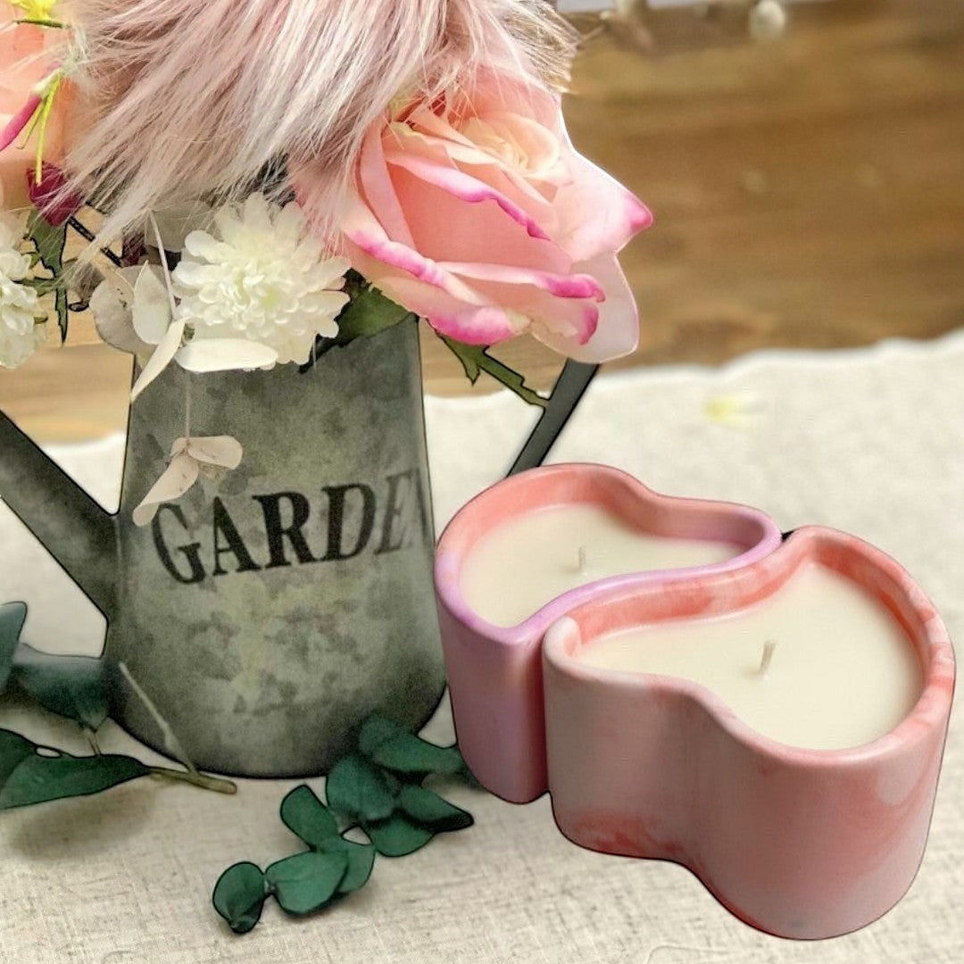 Doodlations Coffee Bar & Boutique heart-shaped concrete candle with pink and white marbling, filled with creamy soy wax.