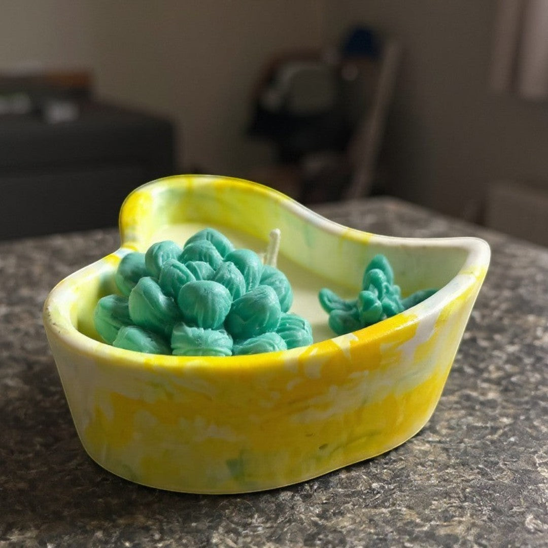 Doodlations heart-shaped concrete candle with teal succulent wax design and yellow marbled finish.