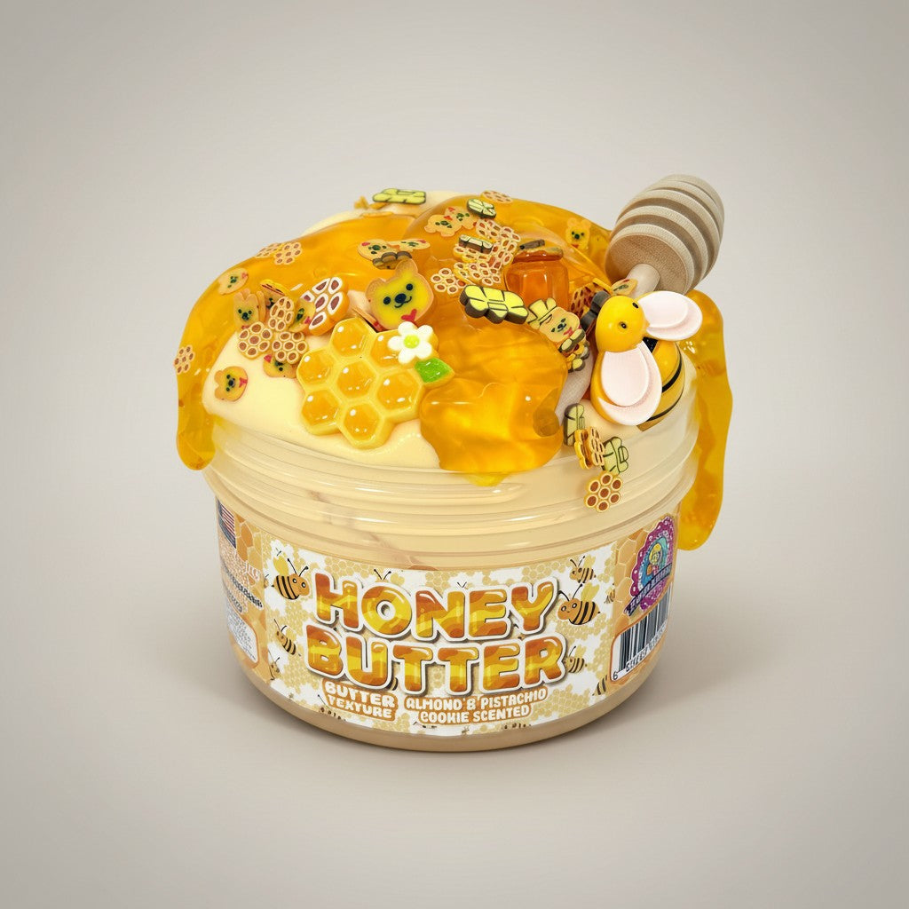 Doodlations Coffee Bar & Boutique Honey Butter slime with a thick, buttery texture, topped with golden honey drizzle, charms, and a honey dipper.
