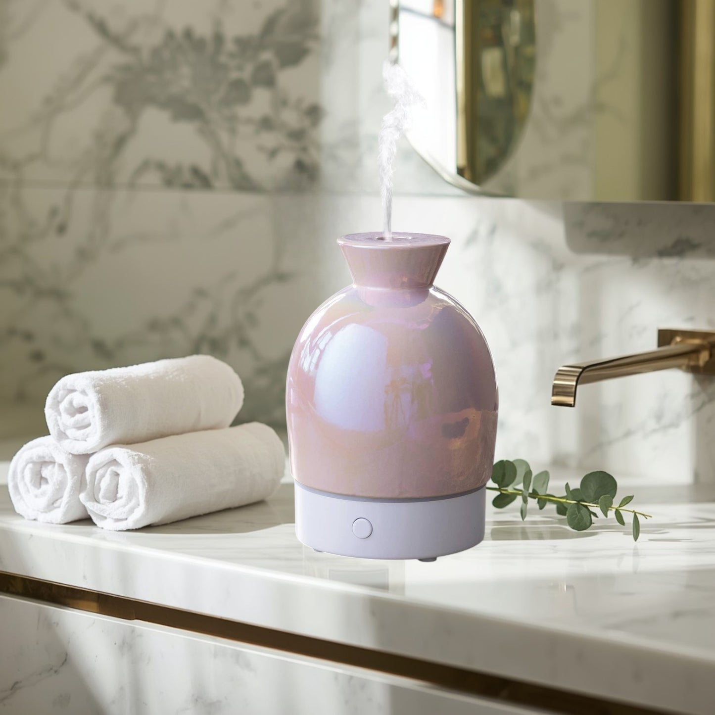 Doodlations Coffee Bar & Boutique iridescent pearlescent aromatic diffuser with white base, emitting mist.