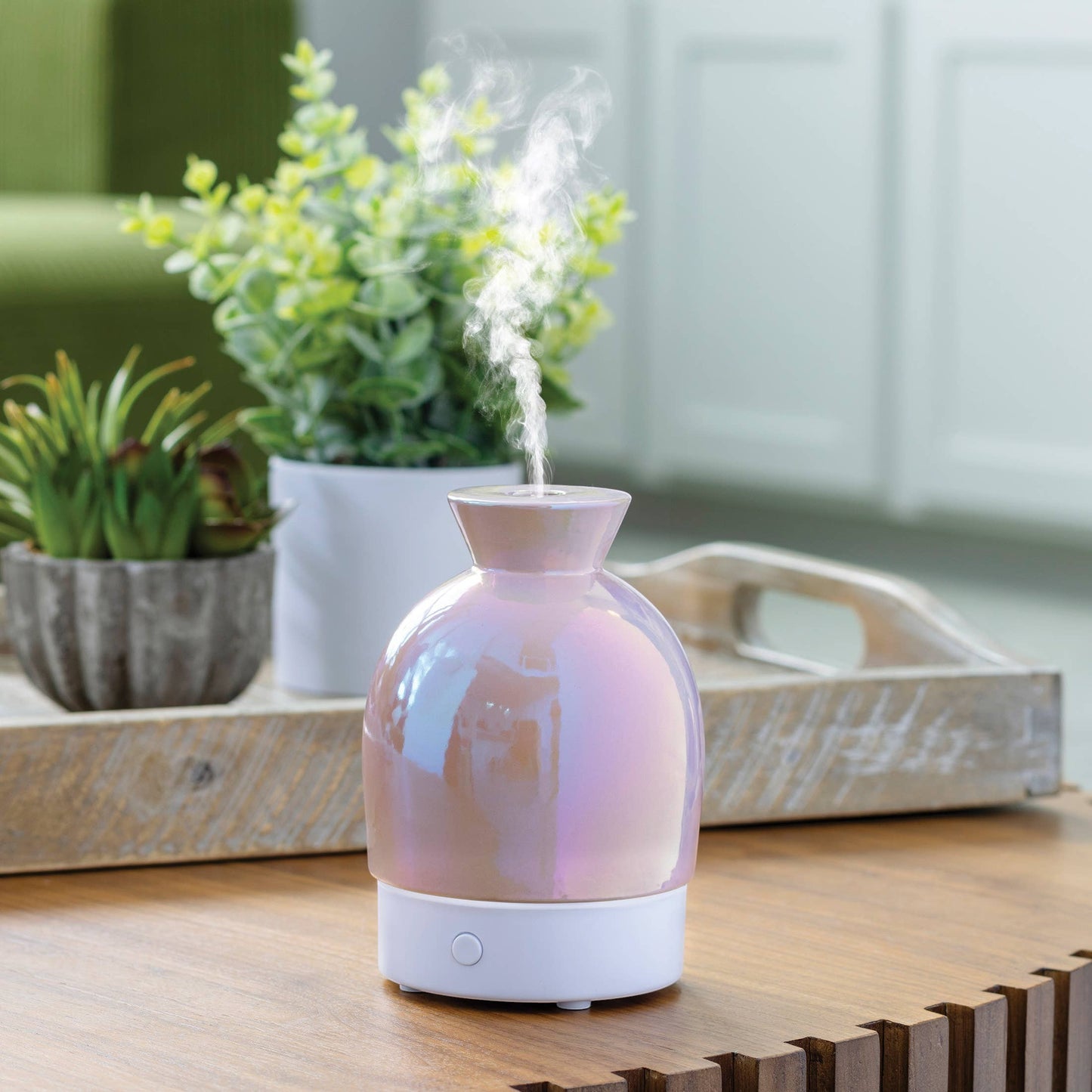 Doodlations Coffee Bar & Boutique iridescent aromatic diffuser with pearlescent hues and white base, emitting steam.