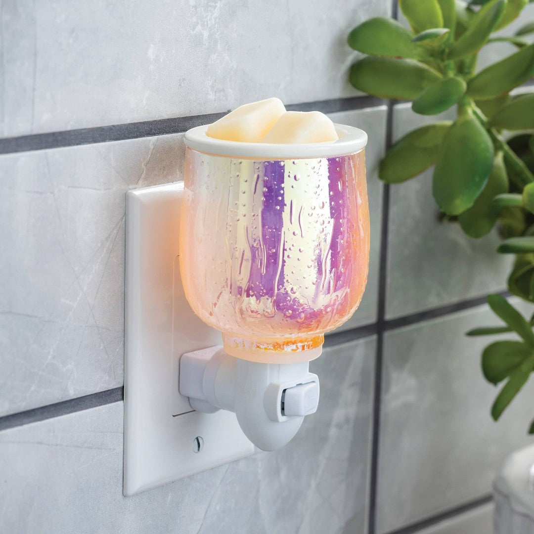 Doodlations Coffee Bar & Boutique iridescent glass plug-in wax warmer with wax melts and a soft glow.