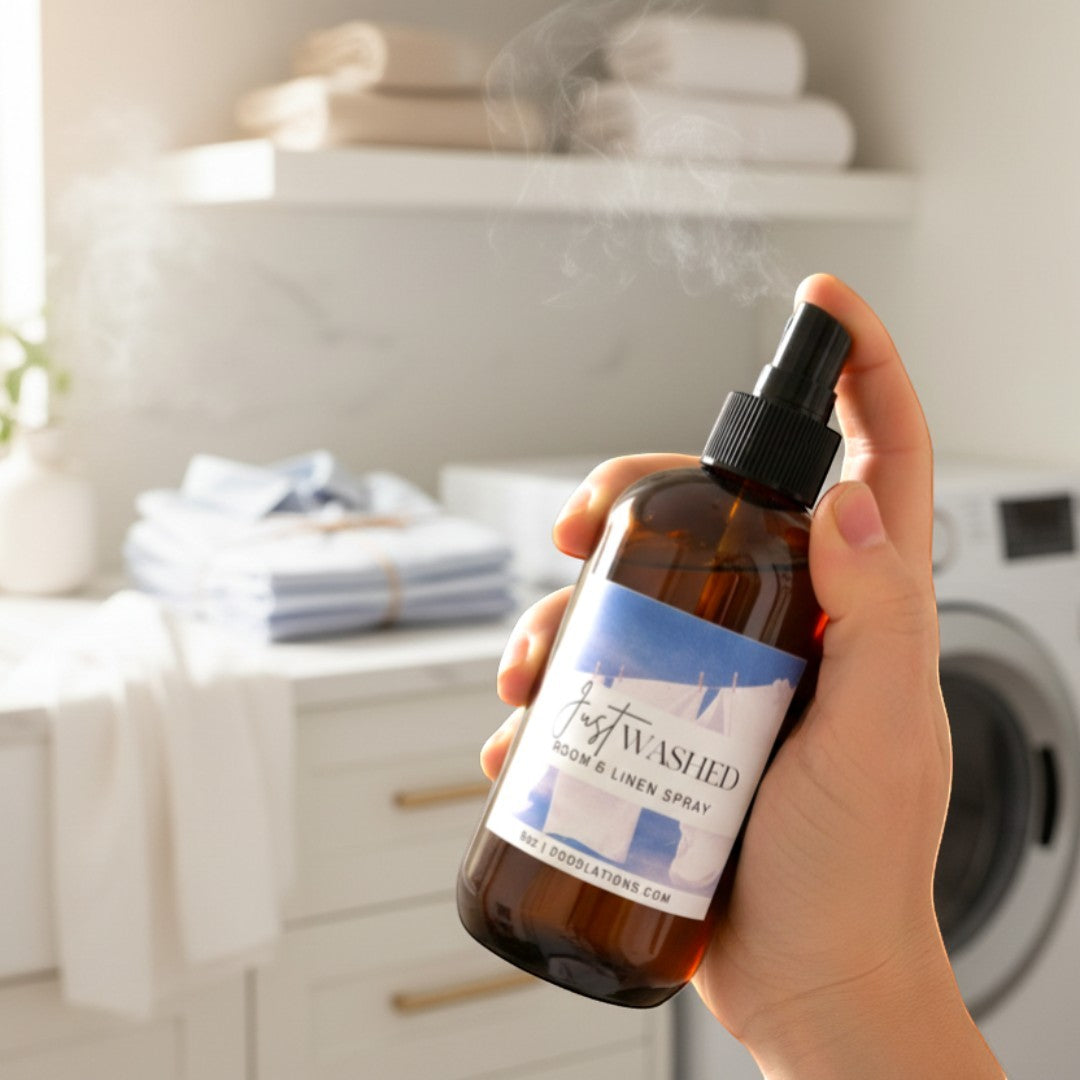 Doodlations Just Washed Room & Linen Spray in amber bottle with blue label, creating a fresh scent.