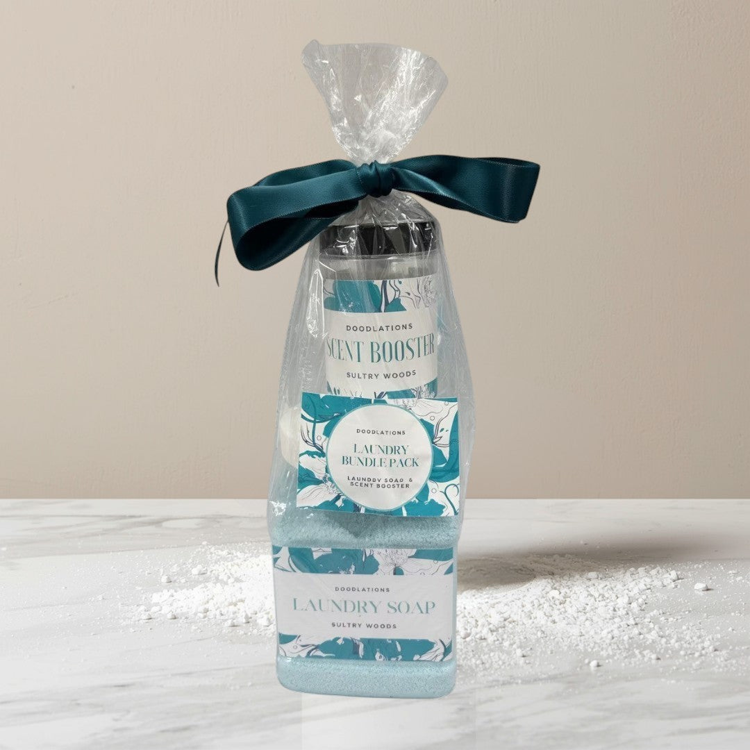 Doodlations Laundry Bundle featuring powdered laundry soap and scent booster in Sultry Woods scent, packaged in a clear bag with a teal ribbon.