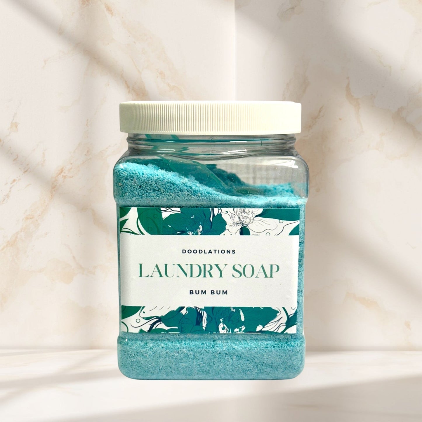 Doodlations Luxury Laundry Powder in Bum Bum scent, a blue granular detergent in a clear jar with a floral label.
